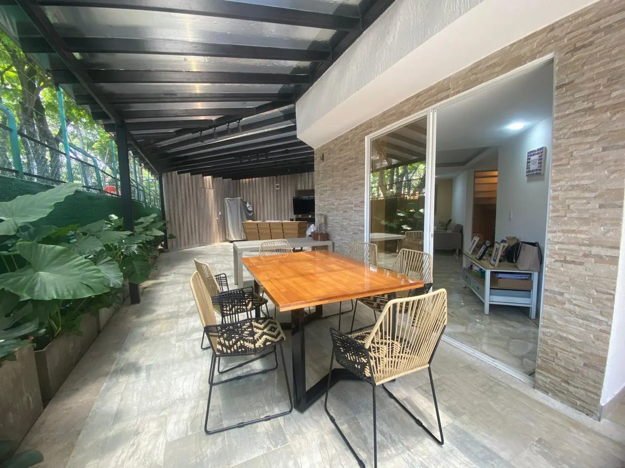 Terraza cubierta con comedor y jardín